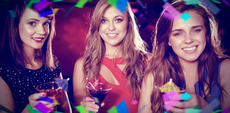 Flying colours against pretty friends drinking cocktails togetherの写真素材