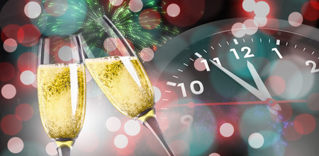 Champagne glasses clinking against colourful fireworks exploding on black backgroundの写真素材