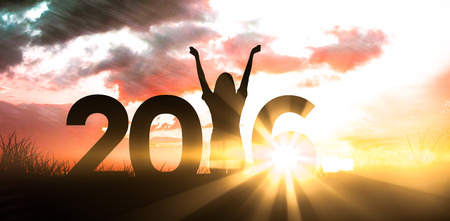 Female silhouette against red sky over grassの写真素材