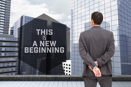 Motivational new years message against businessman standing with hands behind backの写真素材