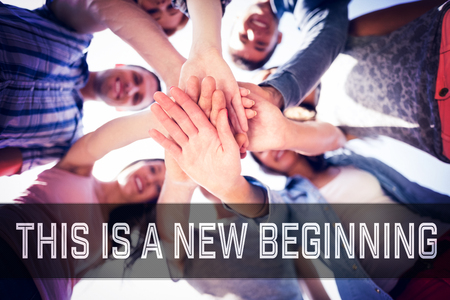 Motivational new years message against happy students putting their hands together