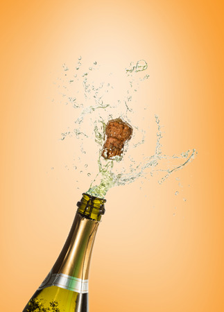 Champagne popping against orange vignetteの写真素材