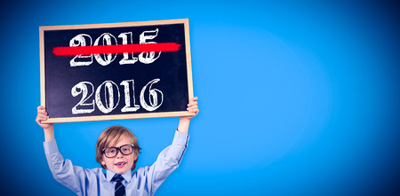 Cute pupil holding chalkboard against blue background with vignetteの写真素材