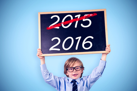 Cute pupil holding chalkboard against blue background with vignetteの写真素材