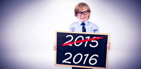 Cute pupil holding chalkboard against grey backgroundの写真素材