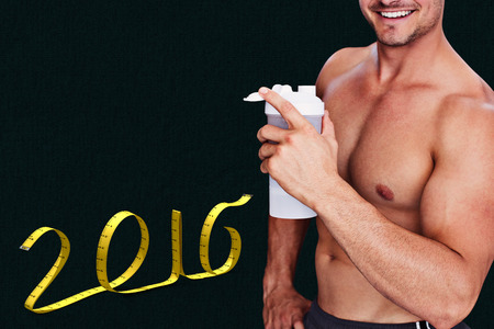 Bodybuilder holding flask against grey background