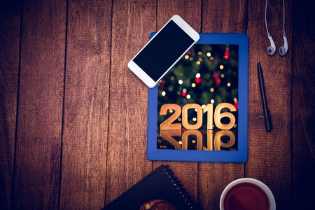 Close up view of business stuff against golden 2016 against illuminated christmas treeの写真素材