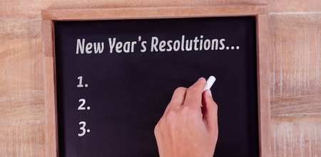 New years resolution list against view of hand writing on blackboardの写真素材