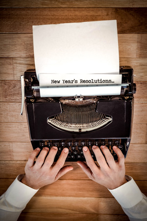 New years resolutions against businessman working on typewriter at table in officeの写真素材