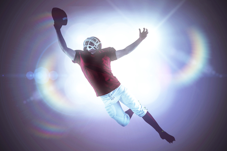 American football player scoring a touchdown against spotlightsの写真素材