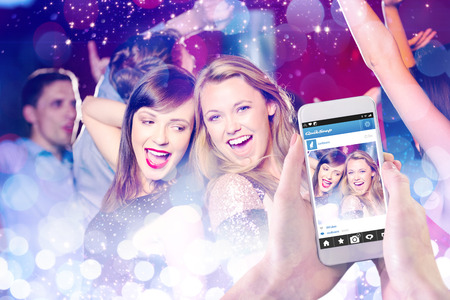 Hand holding smartphone against glowing backgroundの写真素材