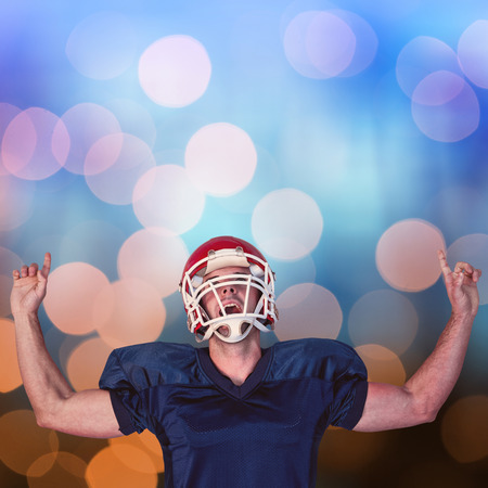 Rugby player celebrating while pointing up against glowing backgroundの写真素材