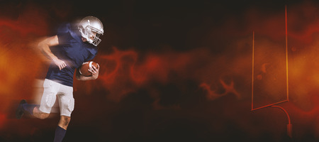 American football player holding ball in mid-air against dark background