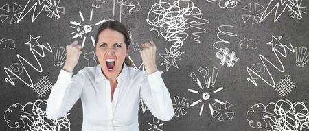 Portrait of screaming businesswoman clanching fists against grey roomの写真素材