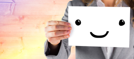 Businesswoman showing a card against yellow and purple planksの写真素材