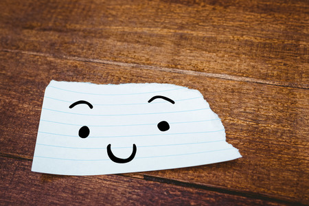 Smiling face against close up view of a piece of paperの写真素材