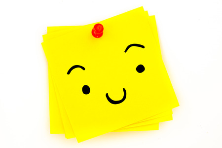 Smiling face against sticky note with red pushpinの写真素材