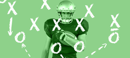 Portrait of American football player holding ball against green vignetteの写真素材