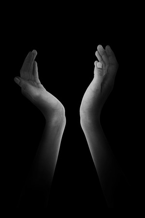 Woman presenting with her hands against blackの写真素材