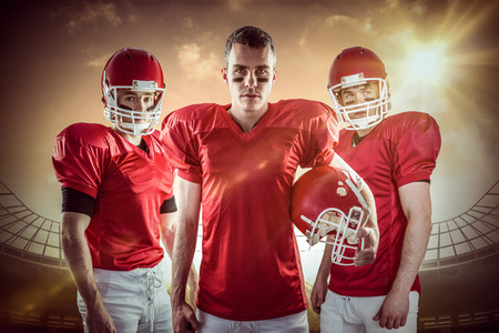 American football team against large football stadium under cloudy blue skyの写真素材