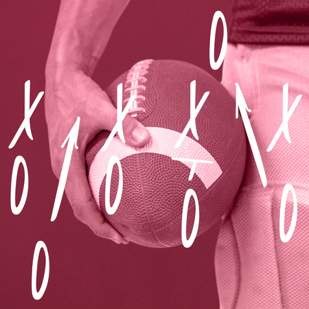 Close-up of sports player holding ball against red backgroundの写真素材