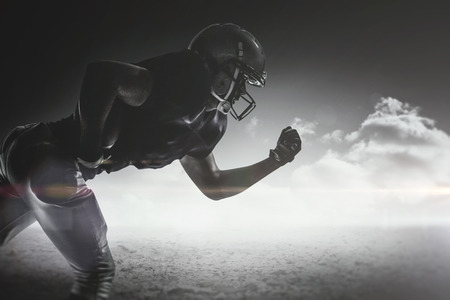Silhouette American football player running against desert landscapeの写真素材