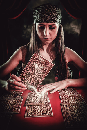 Fortune teller using tarot cards against gloomy skyの写真素材