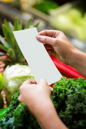 Womans hands holding list at supermarketの写真素材