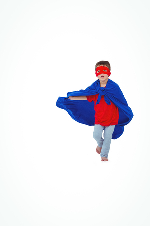 Masked boy running pretending to be superhero on white screenの写真素材