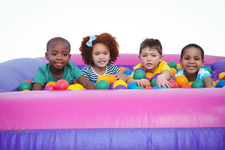 Cute smiling kids in sponge ball pool looking at cameraの写真素材