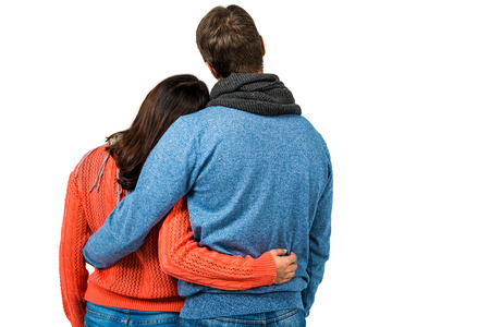 Rear view of couple holding each other against white background