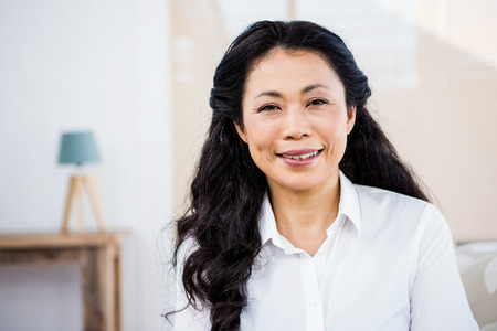 Smiling woman sitting at home on couch