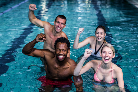 Fit people cycling in the pool with arms raisedの写真素材
