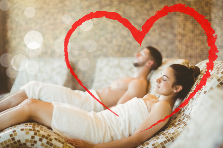 Man and woman lying down together against heartの写真素材
