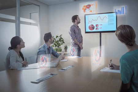Business interface with graphs and data against attentive business team following a presentation