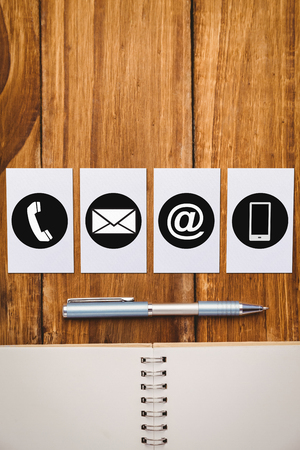 Communication apps against spiral notebook and pen on wooden tableの写真素材