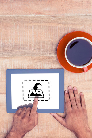 Photography apps against hand using digital tablet over tableの写真素材