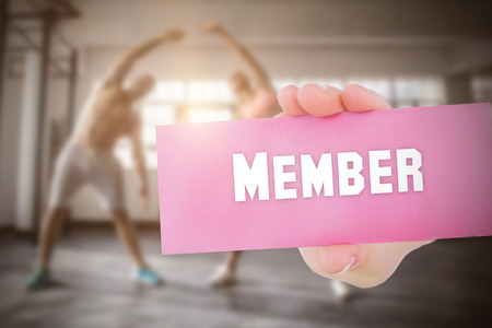 The word member and young woman holding blank card againstの写真素材