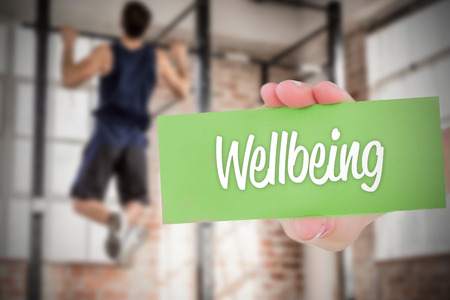 The word wellbeing and hand showing card againstの写真素材