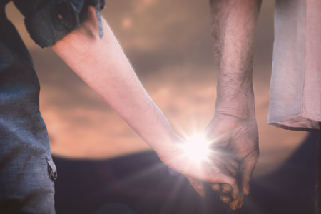 Couple holding hands in park against cloudsの写真素材
