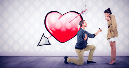Man offering engagement ring to partner against room with wooden floorの写真素材