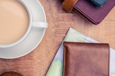 Overhead view of coffee with wallet and diaries on table