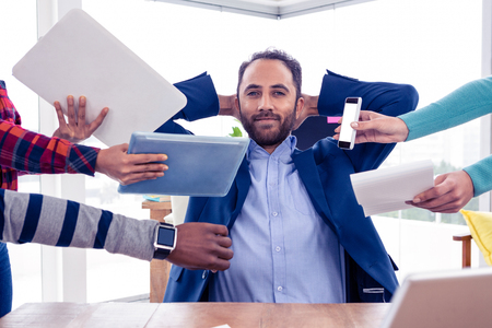 Portrait of smart businessman relaxing with hands behind head in office