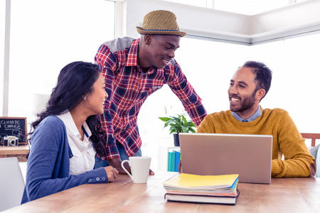 Happy business people discussing with each other at creative office