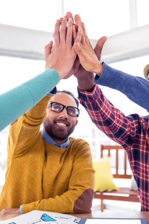 Cheerful Business man doing high five with team in creative office