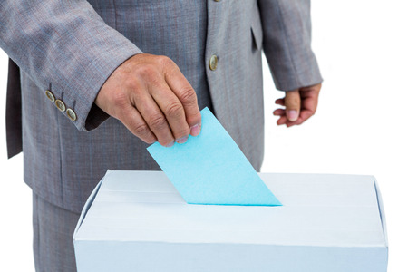 Businessman putting ballot in vote box on white background