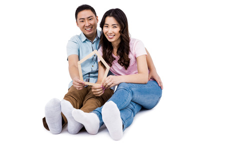 Portrait of happy couple holding frame against white backgroundの写真素材