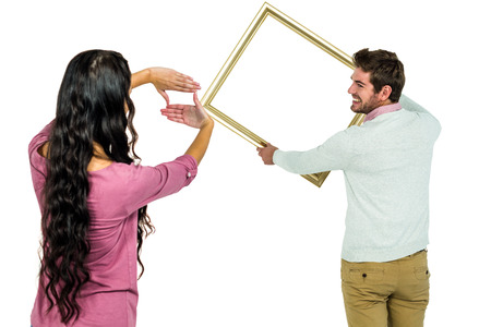 Happy couple holding picture frame on white background