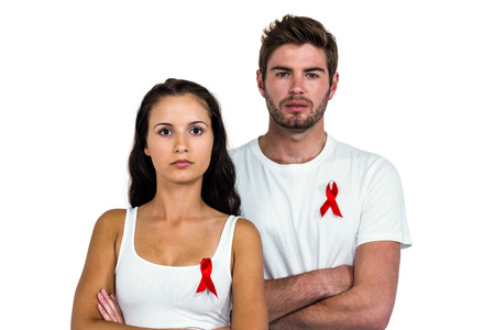 Portrait of serious couple with arms crossed on white backgroundの写真素材