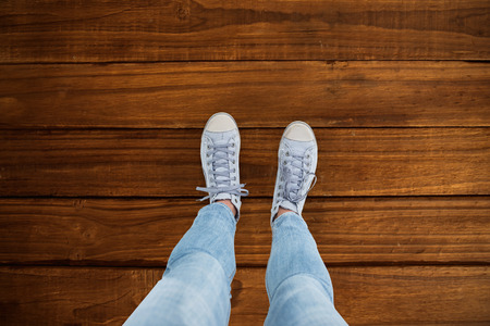 Woman wearing trainers  against overhead of wooden planksの写真素材